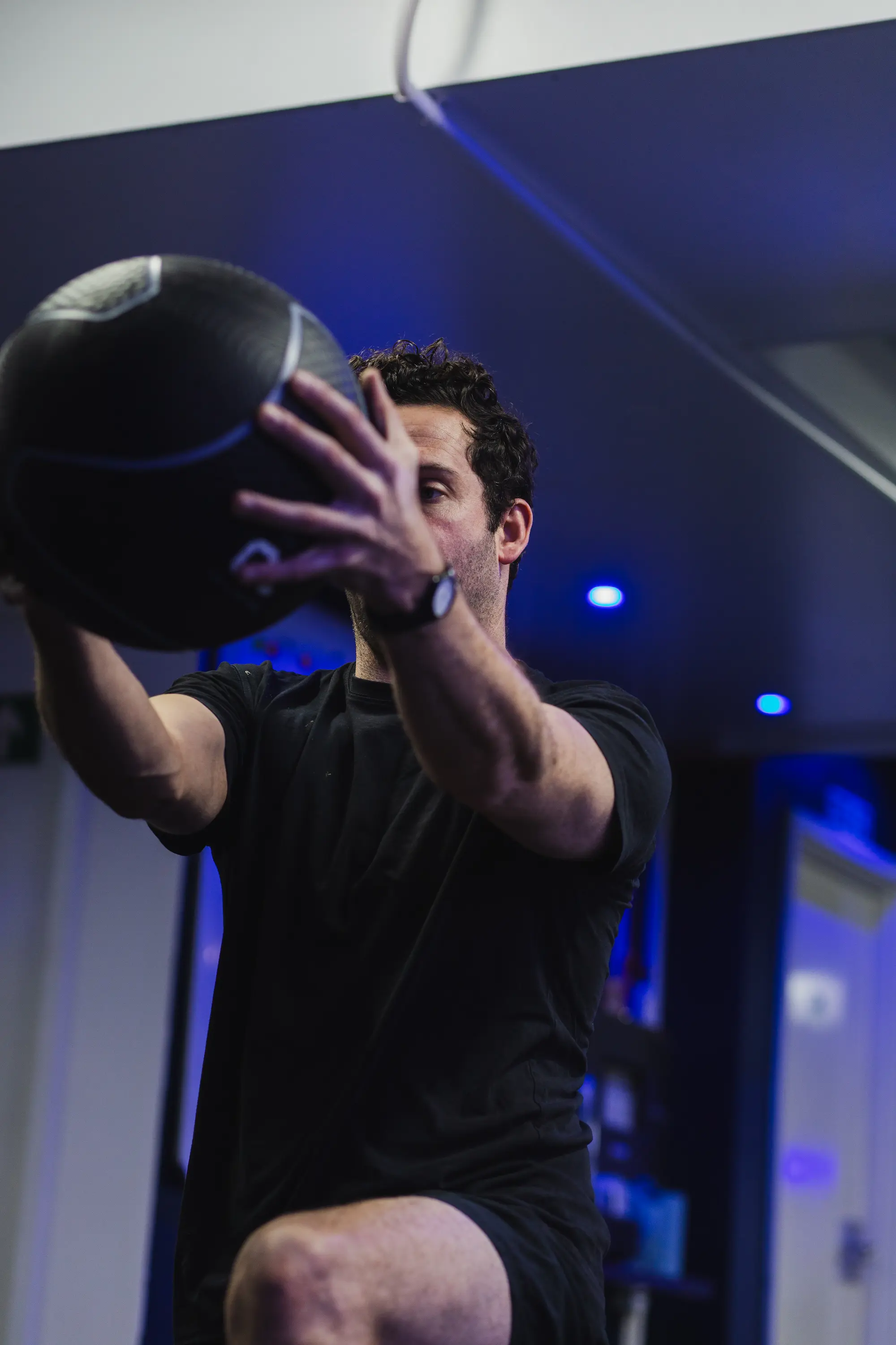 Man holding fitness ball outwards